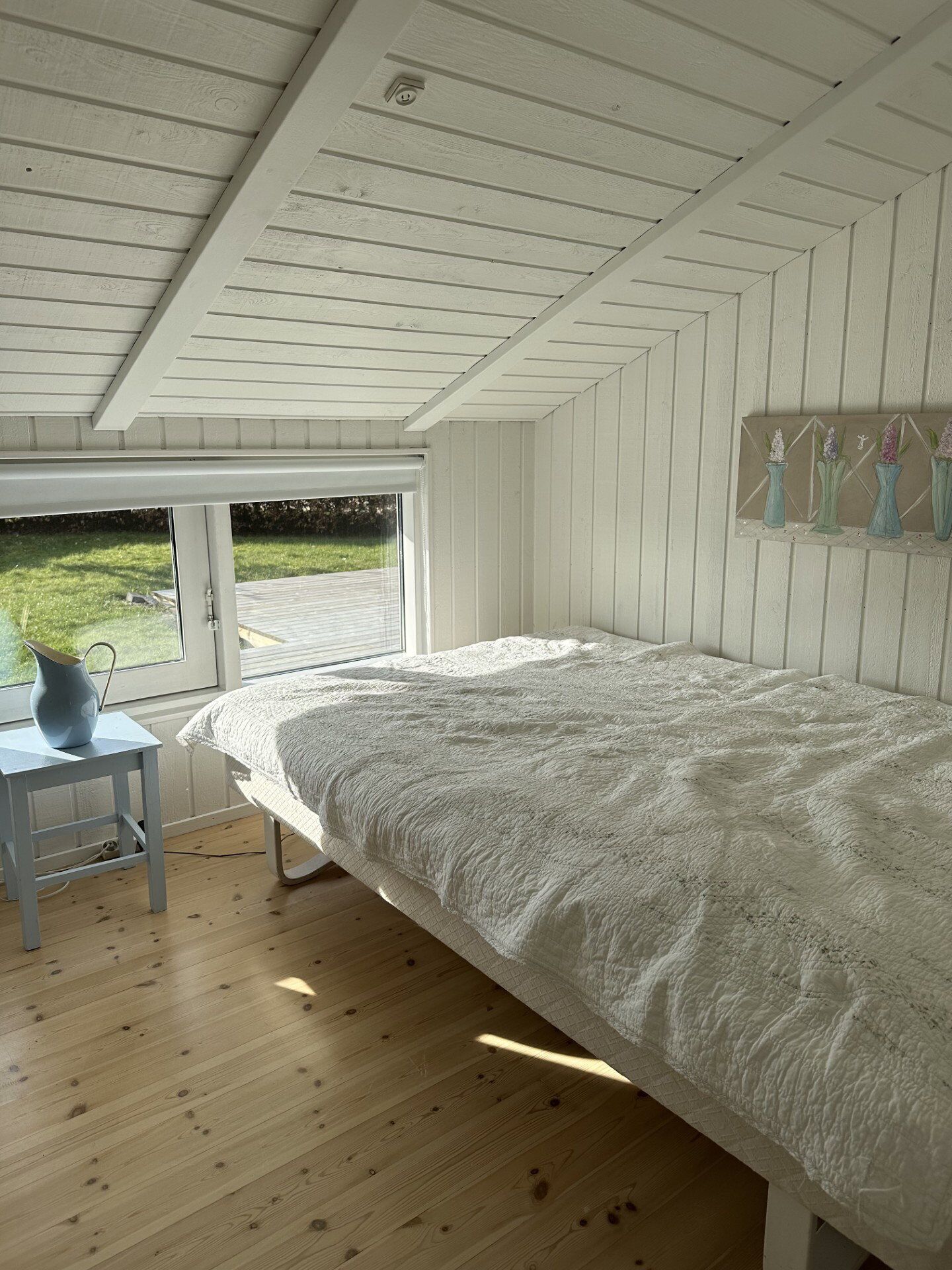 A bedroom with a large bed, a window, and a view of the outdoors.