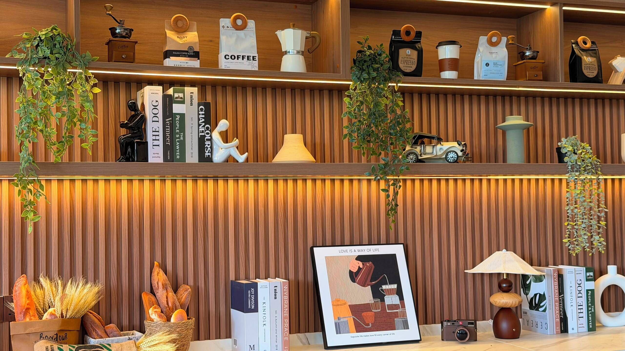 A well-organized shelf with coffee bags, books, a framed picture, and a small car model.