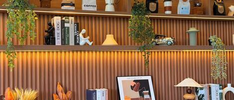 A well-organized shelf with coffee bags, books, a framed picture, and a small car model.
