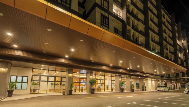 A hotel entrance with a modern design, featuring a covered walkway and multiple floors visible in the background. - Zenith Suites Cameron (Tanah Rata)