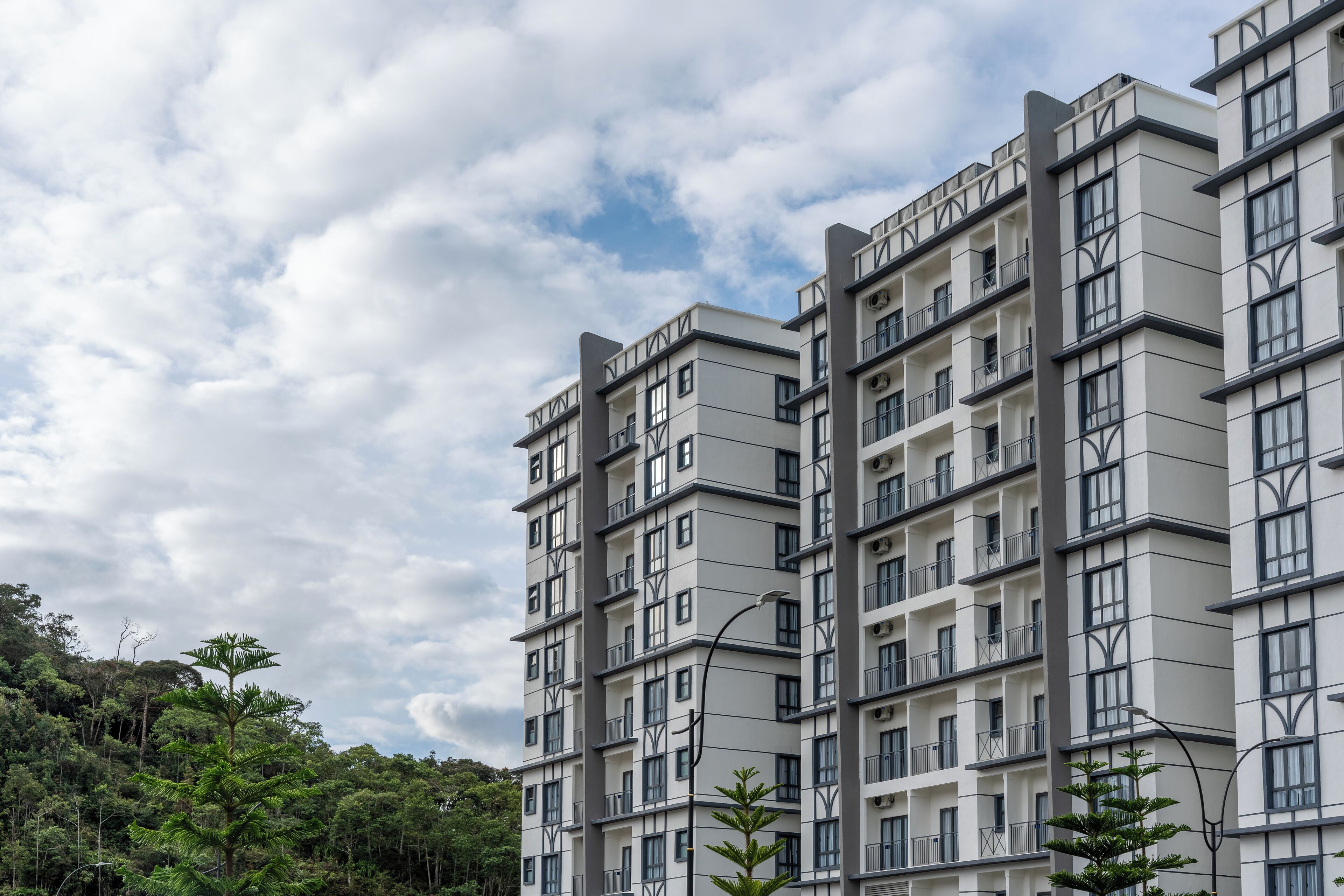 Um edifício residencial com vários andares, varandas e janelas amplas.
