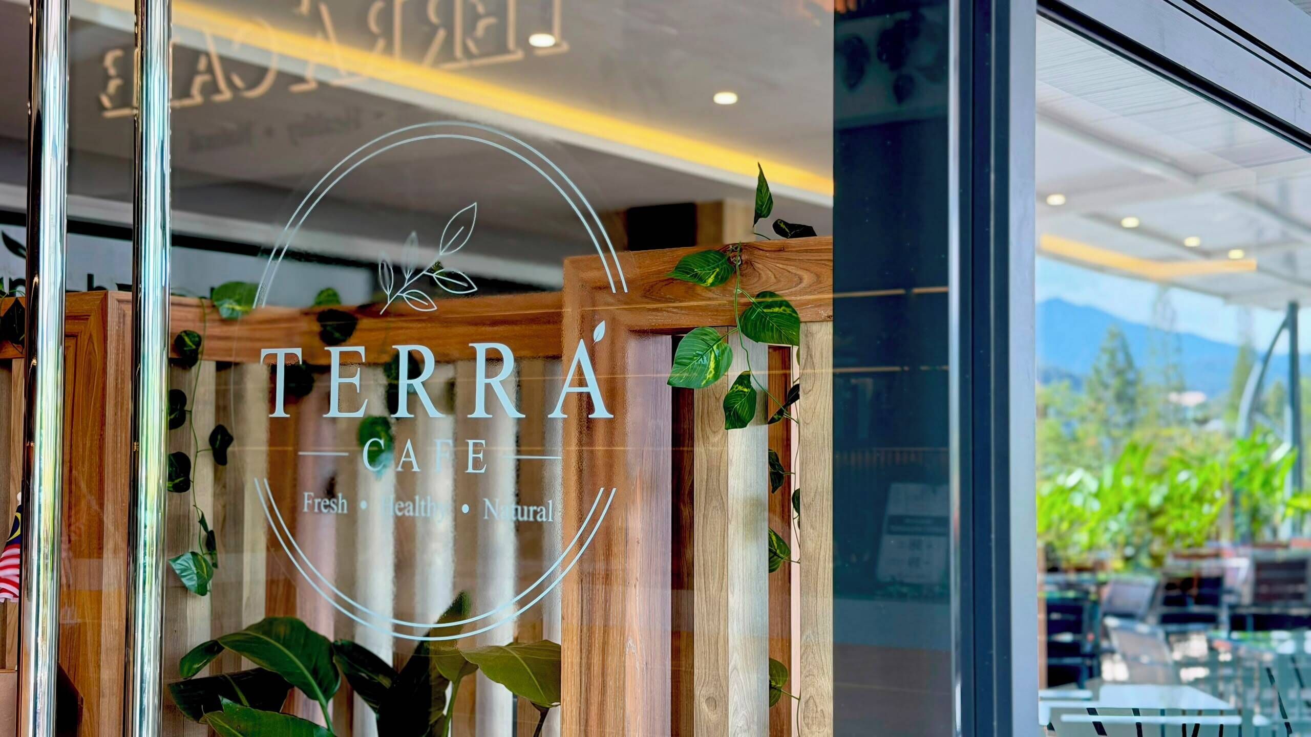 A storefront with the sign 'TERRA CAFE' and the words 'Fresh • Healthy • Natural' indicating the cafe's focus.