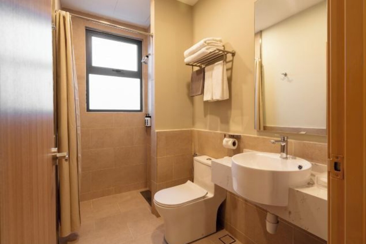 A compact bathroom with a toilet, sink, and towel rack.