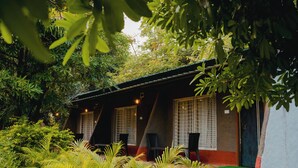 A building with a red and grey exterior, large windows, and a green door. - Wagharanya Resort (Bhadravathi)