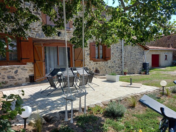 A stone building with a wooden door, a red door, and a sign that reads "FARMHOUSE RESTAURANTE".