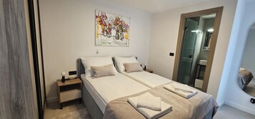 Uma cama de casal com cabeceira, uma mesa de cabeceira e um quadro pendurado na parede.
