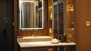 Une salle de bain moderne avec un grand miroir, un lavabo en marbre et des meubles en bois.