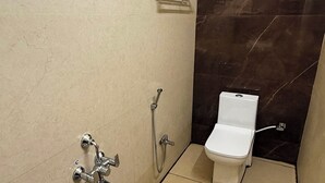 Casa de banho compacta com duche, sanita e lavatório.