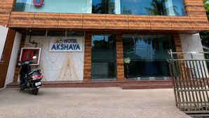 A multi-story hotel with a modern design, featuring large windows and a sign that reads 'HOTEL AKSHAYA'. - Hotel Akshaya (Port Blair)