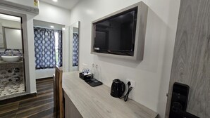 A hotel room with a TV, a sink, a kettle, and a small table. - Hotel Akshaya (Port Blair)