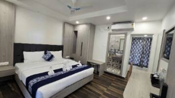 Une chambre d’hôtel moderne dotée d’un grand lit, d’une table de chevet, d’une armoire et d’une salle de bain avec douche et toilettes.