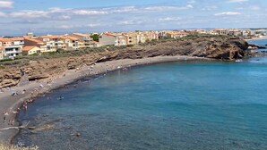 A coastal town with a sandy beach, clear blue waters, and buildings with red-tiled roofs. - Comfortable wooden cabins for rent (heating & air-conditioning). (Clermont-l'Hérault)