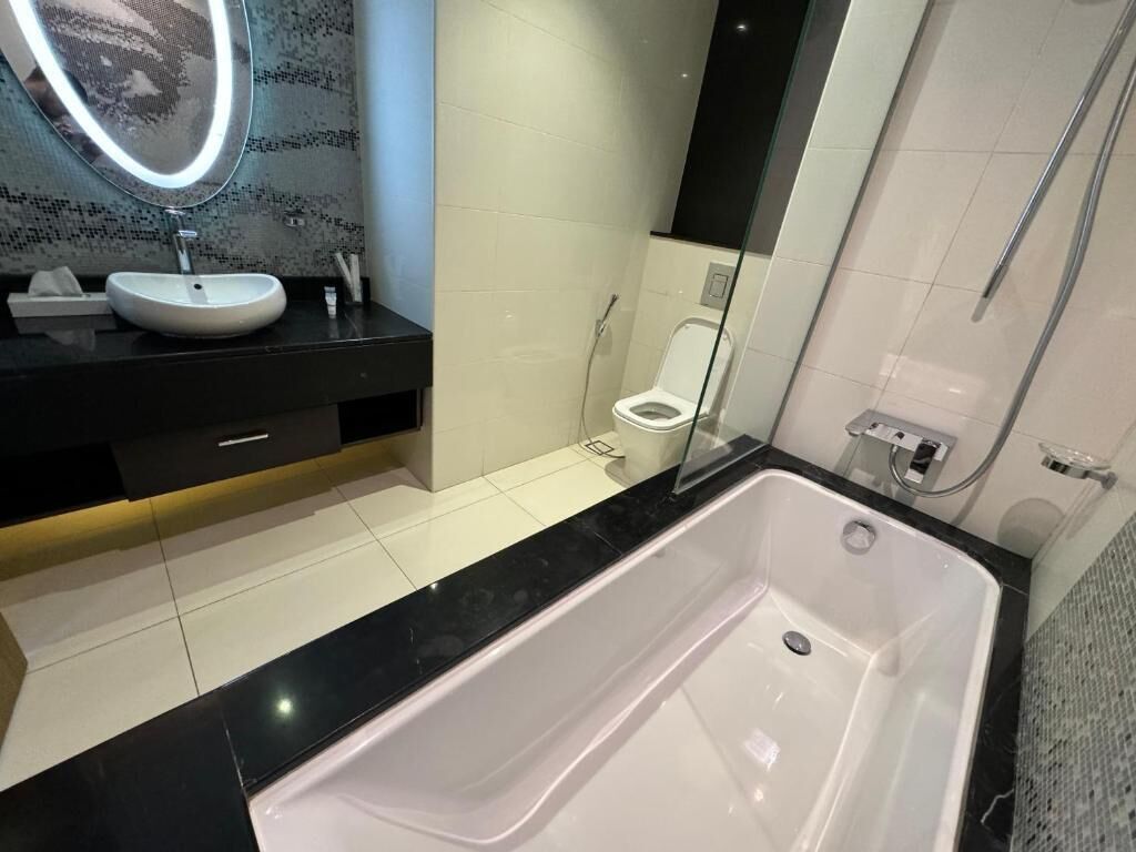 Un baño moderno con una bañera grande, un lavabo y un inodoro.