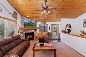 A cozy living room with a fireplace, leather sofa, and a coffee table.