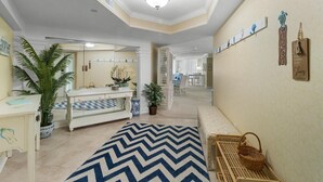 A spacious room with a large mirror, a bed, a bedside table, and a potted plant. - Oceanfront 3 Bdrm Getaway to the Beach Sleeps 6 (Pawleys Island)