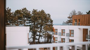 A modern building with multiple balconies and a view of trees and the sea. - Laguna Basen SPA Przy pla y Gara Wifi (Mielno)