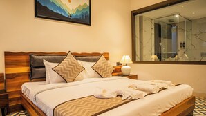 A neatly made bed with a wooden headboard, a bedside table with a lamp, and a large mirror on the wall. - Marvelous villa with AC in Saligao - 5 bedrooms available (Saligao)