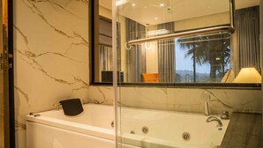 A modern bathroom with a marble wall, a glass-enclosed bathtub, and a large mirror reflecting the room. - Marvelous villa with AC in Saligao - 5 bedrooms available (Saligao)