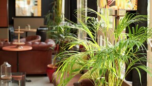 Un ambiente interior acogedor con sofás de cuero, una mesa de vidrio y plantas en macetas.