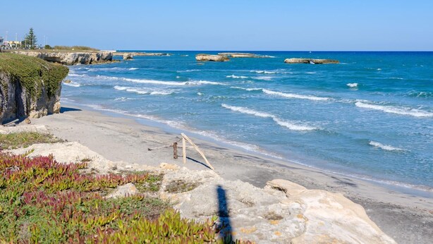 A coastal beach with rocky formations and clear blue water. - Wavefront San Foca (Melendugno)