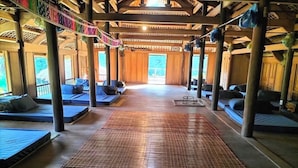 A spacious indoor area with a central walkway, seating areas on either side, and large windows allowing natural light. - Ban Lien Homestay (Ban Lien)