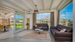A modern living room with a sofa, coffee table, and dining area. - Villa Hemèra, pool and relaxation a few minutes from Scopello (Sicilia)