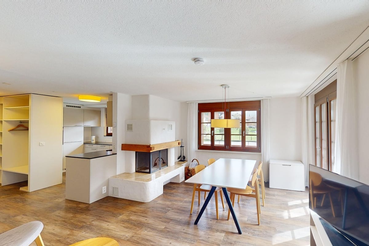 Eine moderne Küche mit Essbereich, Holzboden und großen Fenstern.