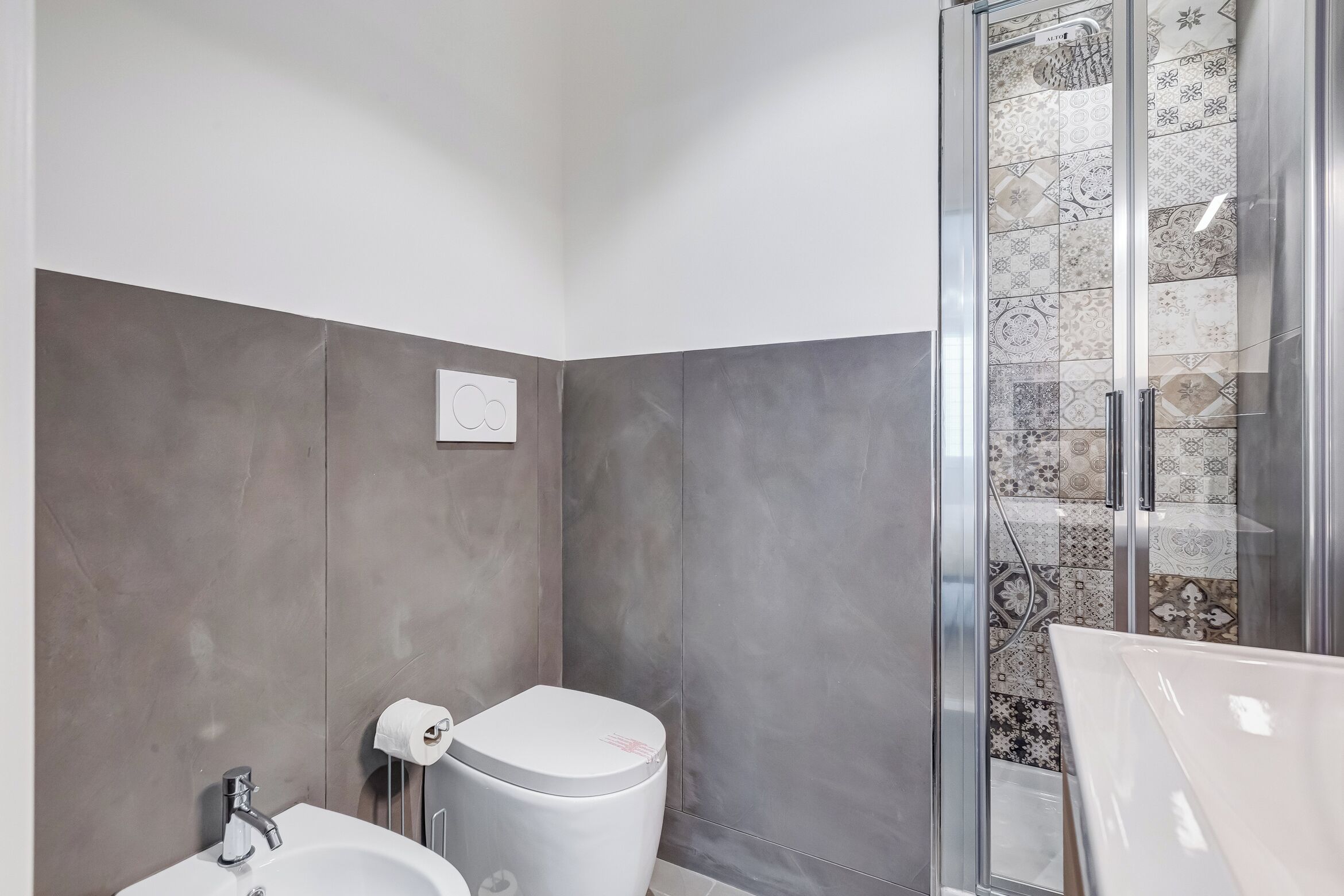 A bathroom with a toilet, sink, and shower area.