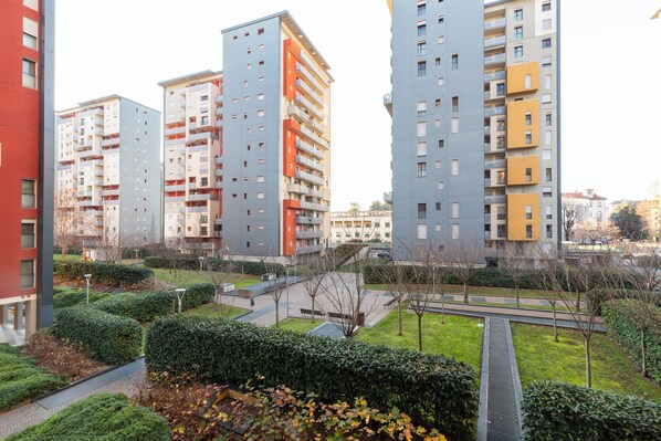 A residential complex with multiple high-rise buildings, a central pathway, and well-maintained greenery. - notaMi - UniGarden - Bicocca District (Milan)
