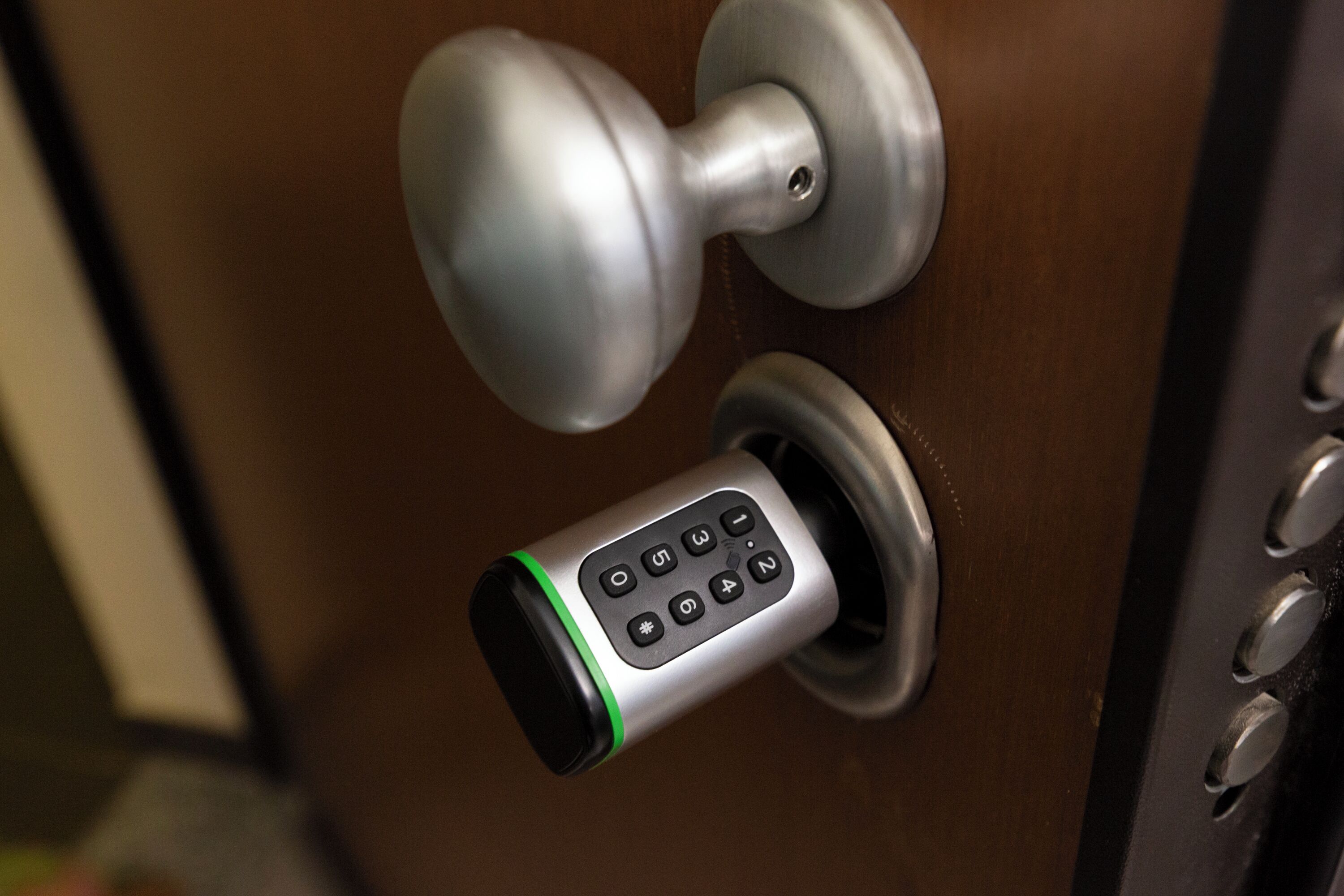 A door with a keypad lock and a round doorknob.