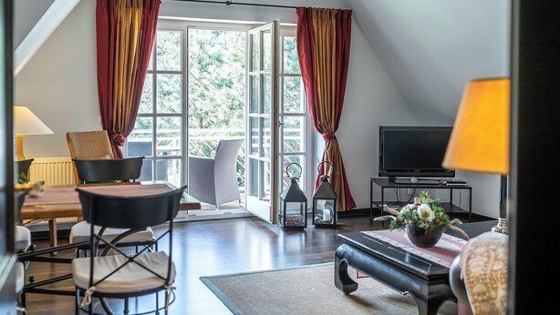 A cozy living room with a TV, seating, and a view of the outdoors.
