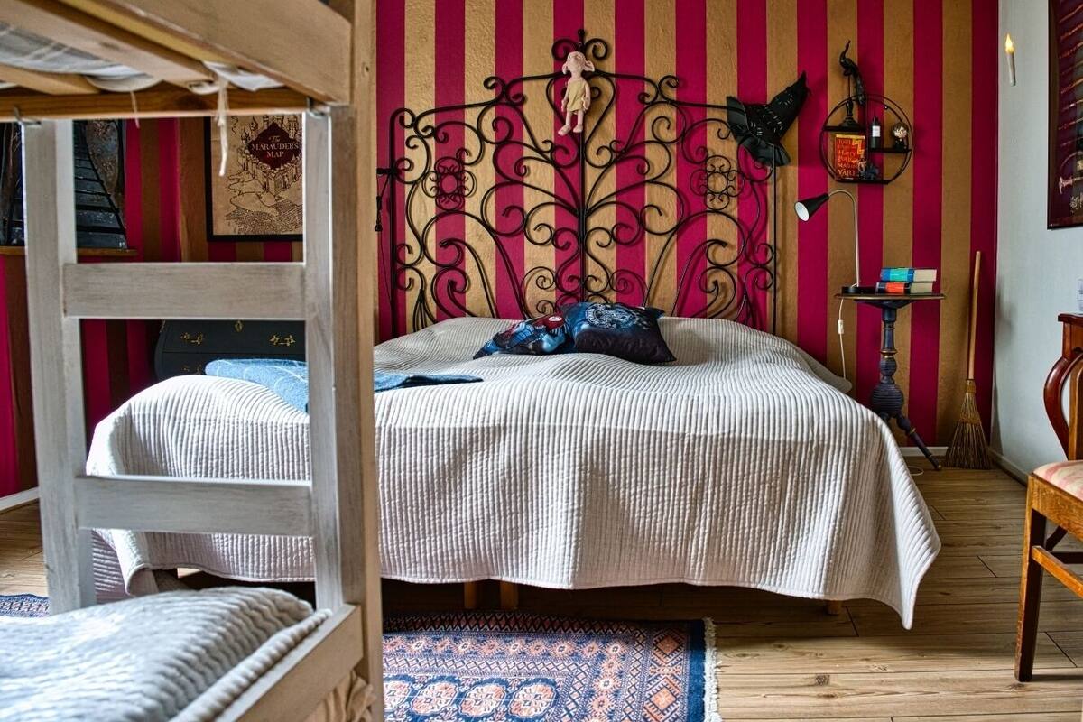 A room with a bunk bed, a patterned rug, and a wall with vertical stripes.