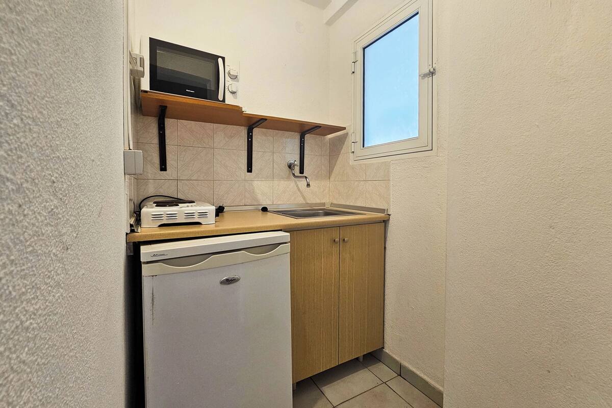 Eine kompakte Küche mit Mikrowelle, Toaster und Geschirrspüler.