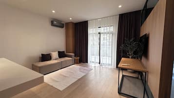 Departamento de lujo, vista al patio | Área de sala de estar | Televisión de pantalla plana