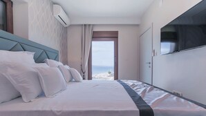 A hotel room with a bed, a TV, and a view of the sea. - "Villa Mendes" - new seafront villa with a swimming pool (Zastražišće)