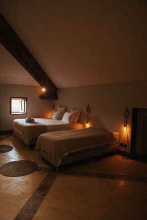 A cozy, dimly lit bedroom with two beds, a small window, and a sloped ceiling. - Intimate estate in the heart of Drôme Provençale (la garde adhemar)