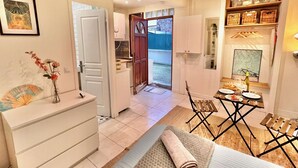 A compact living space with a kitchenette, a dining area, and a small bathroom.