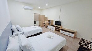 A modern hotel room with two single beds, a TV, a wardrobe, and a desk. - Suvarn Gleaw Thong Resort (Trat)
