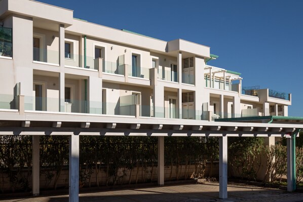 A multi-story building with balconies and a covered walkway. - Loft al Molo by Wonderful Italy (Olbia)