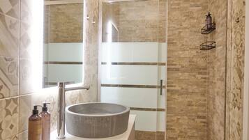 Deluxe driepersoonskamer | Badkamer | Een douche, een haardroger, een bidet, handdoeken