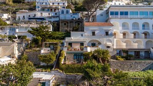 Une ville côtière aux bâtiments blancs, aux maisons à étages et à la végétation luxuriante.