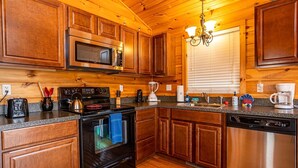 A kitchen with wooden cabinets, a stainless steel microwave, a coffee maker, and a dishwasher. - Charming riverside with stunning views, cozy interiors, full amenities, and spacious decks. (Draper)
