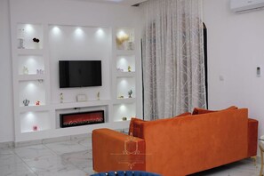 Deluxe Suite, Garden View | Living area | Smart TV - Les Jardins de René - London (Yaoundé)