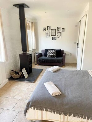 A cozy room with a bed, a sofa, a fireplace, and framed pictures on the wall. - Cosy Annex sleeps 2 near Gretna, M6 Jct 45 / A75

 (Rigg)