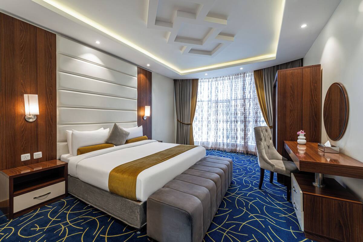 Una habitación de hotel moderna con una cama grande, un escritorio y una silla.