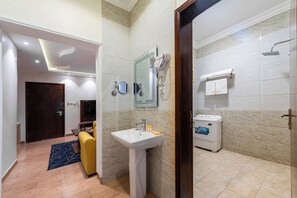 Een moderne badkamer met een wastafel, spiegel en douche.