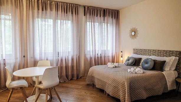 Un dormitorio con cama, mesita de noche y una silla.