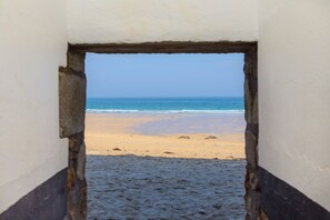A doorway leading to a beach with a clear view of the ocean. - The Old Salthouse, St Ives – Sleeps 2, On-Site Parking (St Ives)