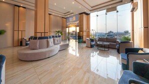 A spacious lobby with a curved sofa, a coffee table, and seating area. - Al Qasr Hotel Suites - Al Iskan District (Khamis Mushait)