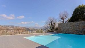 A swimming pool with a stone wall and a view of a cityscape. - NICE 130m2 Terrace with PANORAMIC VIEW, Swimming Pool, Free Parking, A/C, WIFI (Nice)